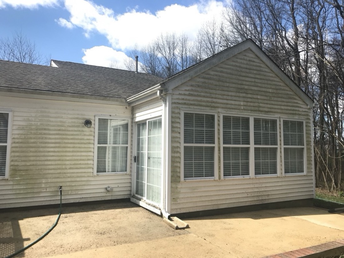 House siding and patio exterior with visible buildup before cleaning